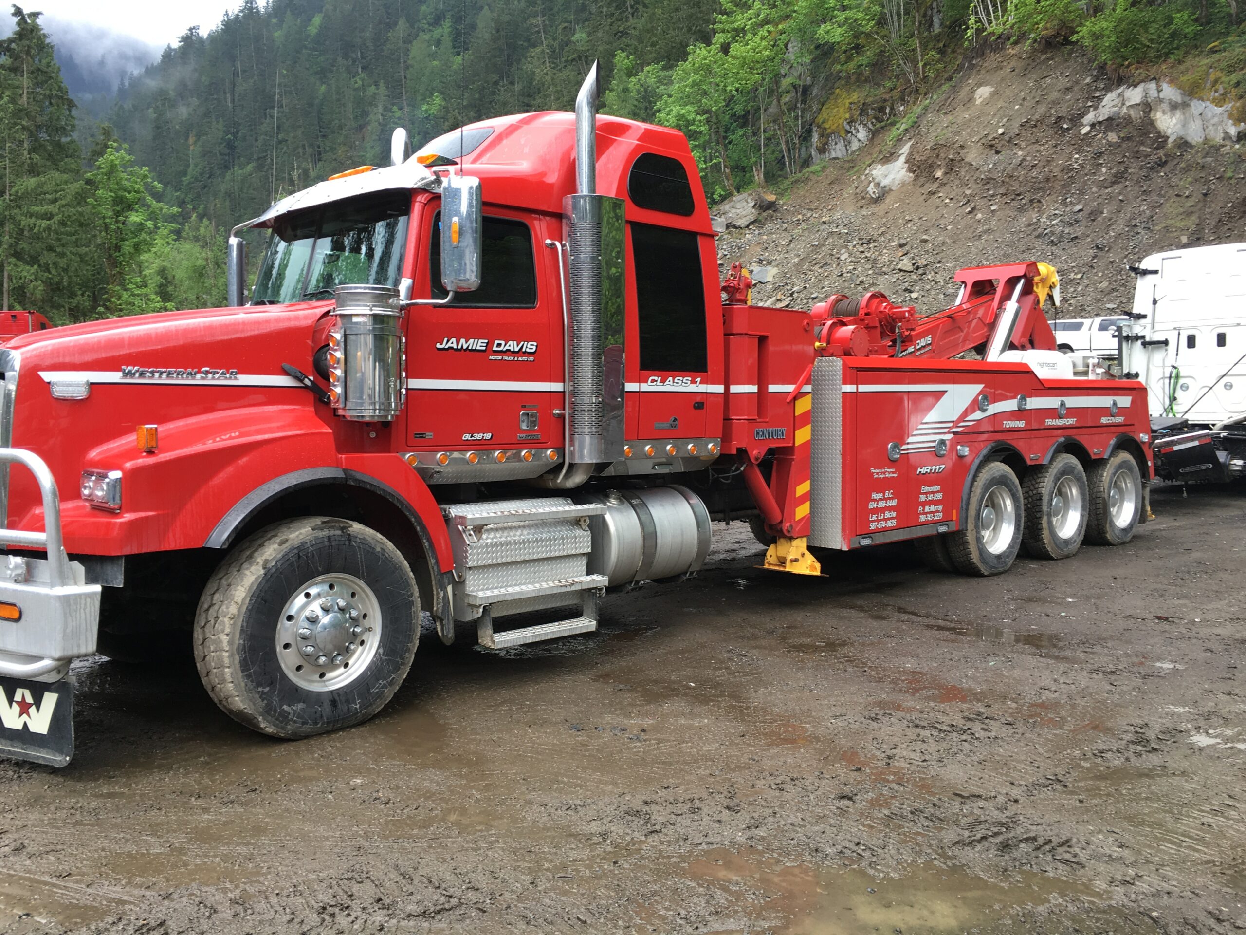 Jamie Davis red heavy duty tow truck towing a truck